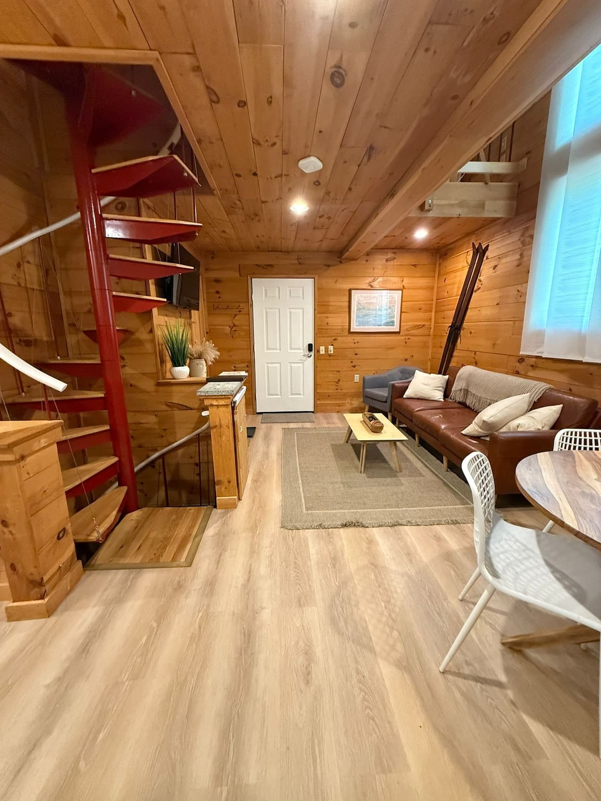 Warm knotty-pine living room with the signature red spiral staircase